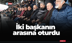 İki başkanın arasına oturdu